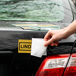 Rectangle shaped decal being applied to a tailgate with extra vinyl decals waiting nearby.